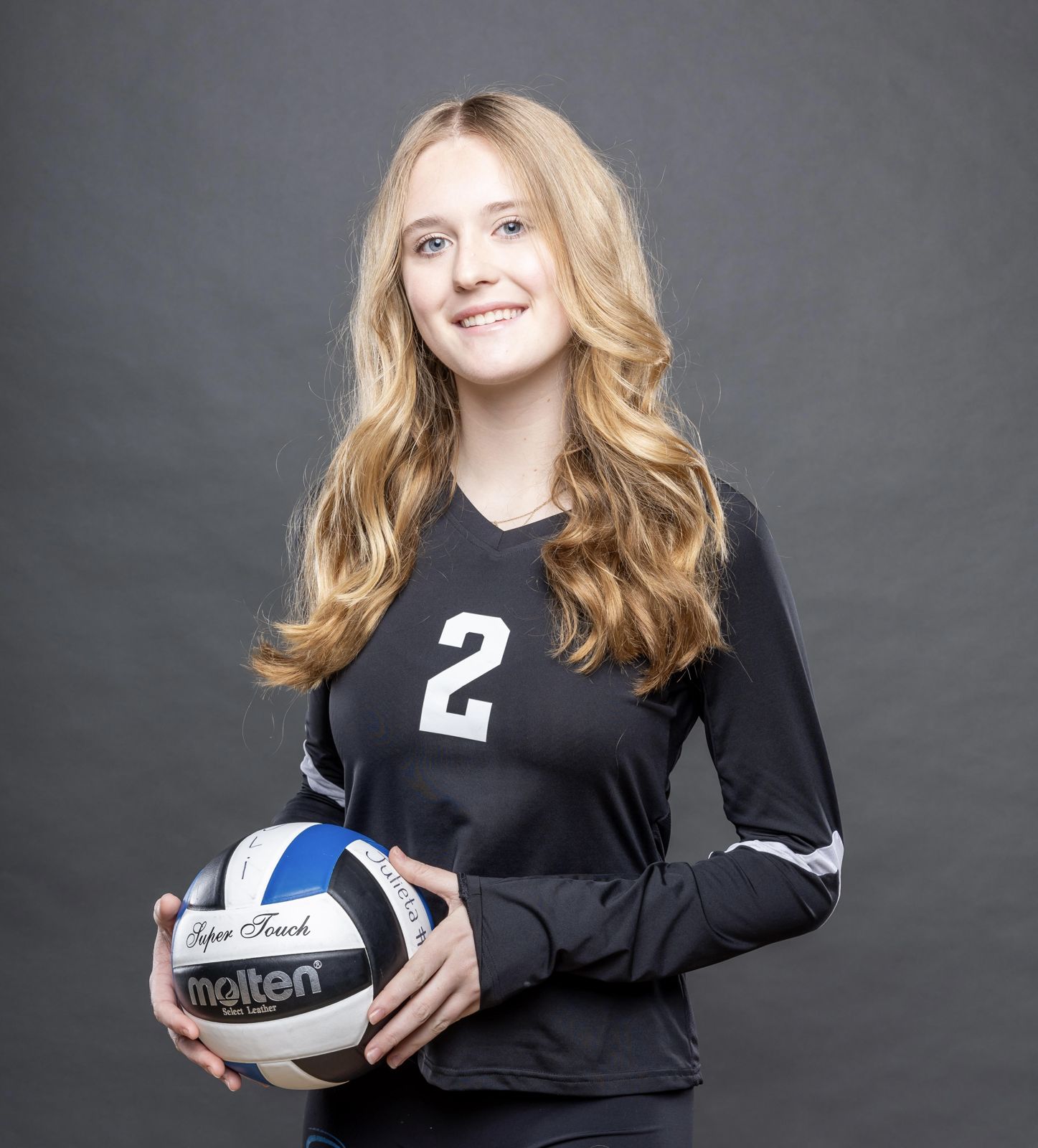 Savannah Wooley holding a volleyball in her #2 club jersey